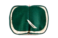 Load image into Gallery viewer, Interior view of jewelry/sewing case showing cream colored lining and pockets with dark green felt pages.