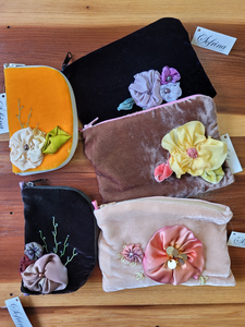 Examples of silk flowers on some small bags and needle cases.
