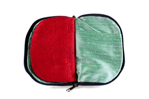 Interior view of jewelry/sewing case showing mermaid iridescent teal lining with pockets and red felt pages.