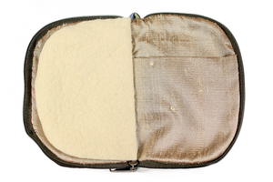 Interior view of jewelry/sewing case showing a gold lining and pockets and cream colored felt pages.