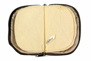 Interior view of jewelry/sewing case showing a gold lining and cream colored felt pages.