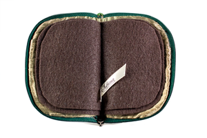 Interior view of jewelry/sewing case, showing dark gold lining and pockets, and dark brown pages.