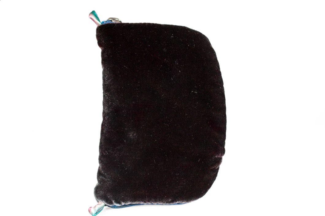 Front view of dark brown velvet jewelry/sewing case with midnight blue zipper. Two small silk loops are situated at the top and bottom of the case in a gradient of pink, white, and teal.