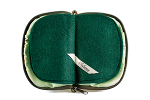 Interior view of jewelry/sewing case showing shimmery light green lining and pockets and dark green felt pages.