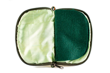 Load image into Gallery viewer, Interior view of jewelry/sewing case showing shimmery light green lining and pockets and dark green felt pages. 
