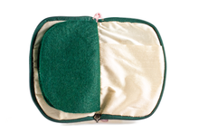 Load image into Gallery viewer, Interior view of jewelry/sewing case showing cream colored lining and pockets with dark green felt pages.
