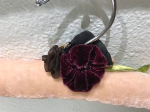 Close-up view of Blush Velvet Padded Hanger showing off the burgundy velvet flower and a brown flower.